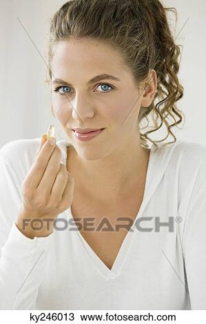 Portrait of a woman taking an Omega-3 capsule View Large Photo Image Stock Image - Portrait of a woman taking an Omega-3 capsule. Fotosearch