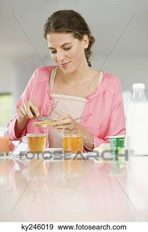 Woman having breakfast at a table View Large Photo Image Stock Photo - Woman having breakfast at a table. Fotosearch