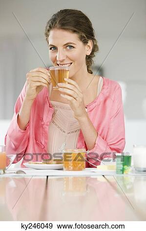 Woman having breakfast at a table View Large Photo Image Stock Photo - Woman having breakfast at a table. Fotosearch