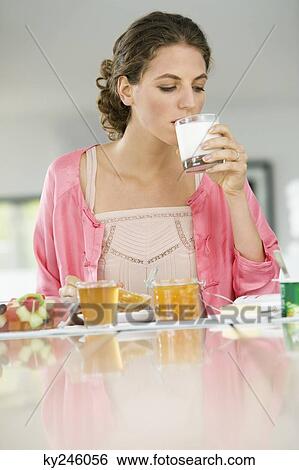 Woman having breakfast at a table View Large Photo Image Stock Photograph - Woman having breakfast at a table. Fotosearch