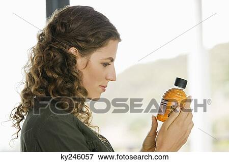Woman holding a bottle of olive oil in the kitchen View Large Photo Image Stock Photo - Woman holding a bottle of olive oil in the kitchen. Fotosearch