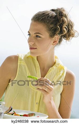 Stock Photo - Woman holding a pea pod. Fotosearch