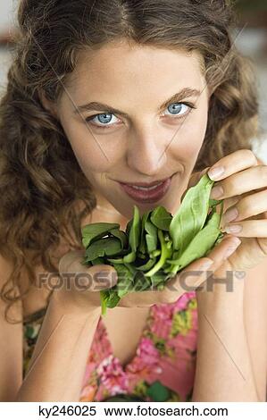Woman smelling spinach leaves in the kitchen View Large Photo Image Stock Photography - Woman smelling spinach leaves in the kitchen. Fotosearch