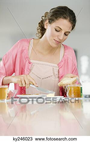 Woman spreading butter on a bread View Large Photo Image Stock Image - Woman spreading butter on a bread. Fotosearch