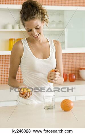 Woman squeezing an orange View Large Photo Image Stock Photo - Woman squeezing an orange. Fotosearch