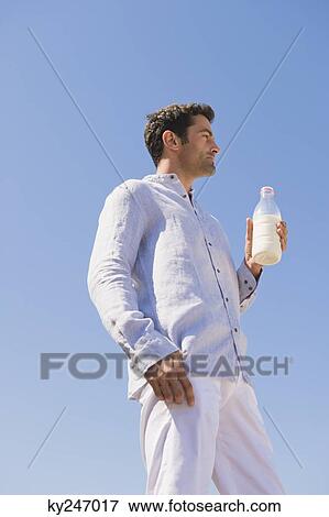 Man holding milk bottle on the beach View Large Photo Image Stock Photo - Man holding milk bottle on the beach. Fotosearch