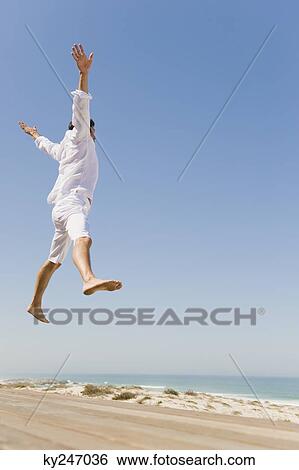 Man jumping on the beach View Large Photo Image Stock Photograph - Man jumping on the beach. Fotosearch