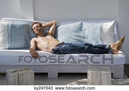 Man resting on a couch View Large Photo Image Stock Image - Man resting on a couch. Fotosearch