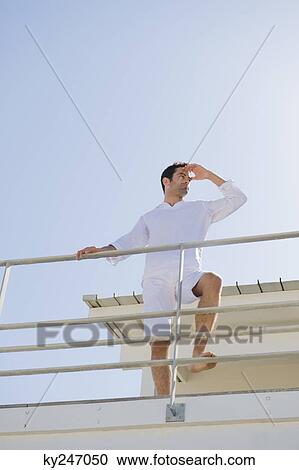 Man standing on the beach house View Large Photo Image Stock Image - Man standing on the beach house. Fotosearch