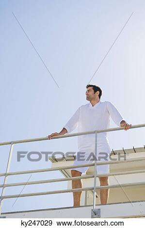 Man standing on the beach house View Large Photo Image Stock Photo - Man standing on the beach house. Fotosearch