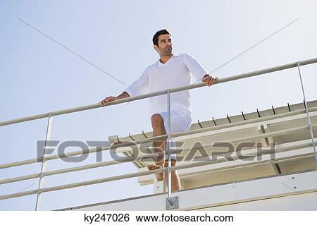 Man standing on the beach house View Large Photo Image Stock Photograph - Man standing on the beach house. Fotosearch