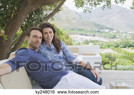 Stock Photograph - Couple sitting on a couch. Fotosearch