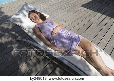 High angle view of a woman resting on a deck chair View Large Photo Image Stock Image - High angle view of a woman resting on a deck chair. Fotosearch
