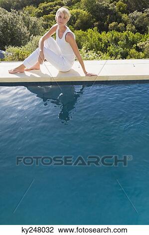 Woman sitting at the poolside View Large Photo Image Stock Image - Woman sitting at the poolside. Fotosearch