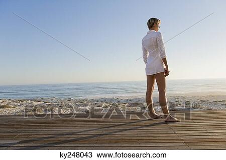 Woman standing on a boardwalk View Large Photo Image Stock Image - Woman standing on a boardwalk. Fotosearch