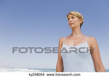 Picture - Woman standing on the beach. Fotosearch