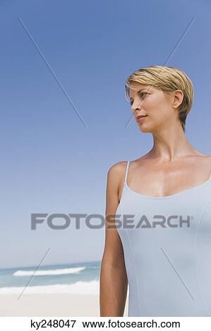 Woman standing on the beach View Large Photo Image Stock Photo - Woman standing on the beach. Fotosearch