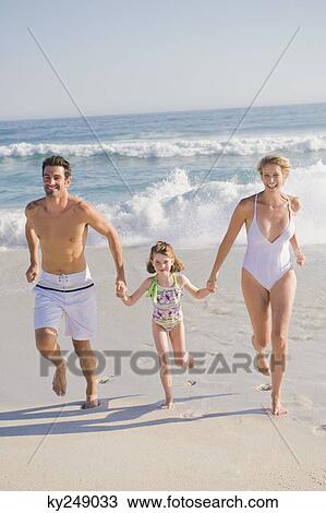 Stock Image - Family enjoying vacations on the beach. Fotosearch