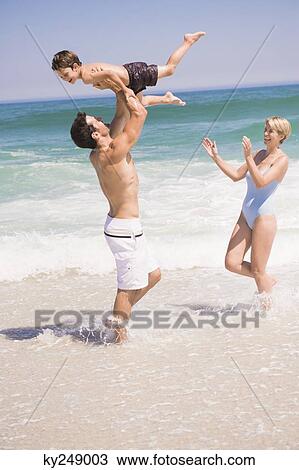 Stock Image - Family playing on the beach. Fotosearch