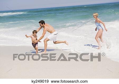 Family playing on the beach View Large Photo Image Stock Photo - Family playing on the beach. Fotosearch