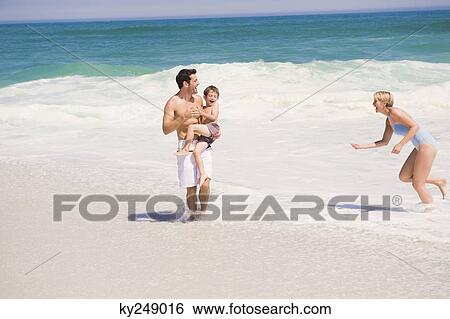 Family playing on the beach View Large Photo Image Stock Photograph - Family playing on the beach. Fotosearch