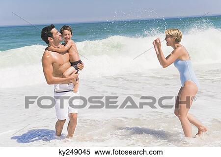Stock Photography - Family playing on the beach. Fotosearch