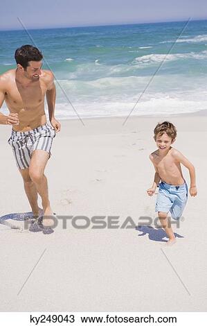 Man running with his son on the beach View Large Photo Image Stock Image - Man running with his son on the beach. Fotosearch