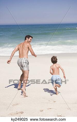 Man running with his son on the beach View Large Photo Image Stock Photography - Man running with his son on the beach. Fotosearch