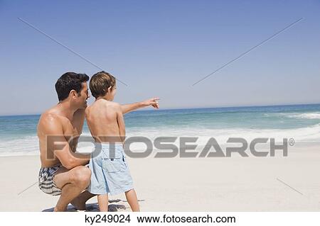 Man with his son pointing on the beach View Large Photo Image Picture - Man with his son pointing on the beach. Fotosearch