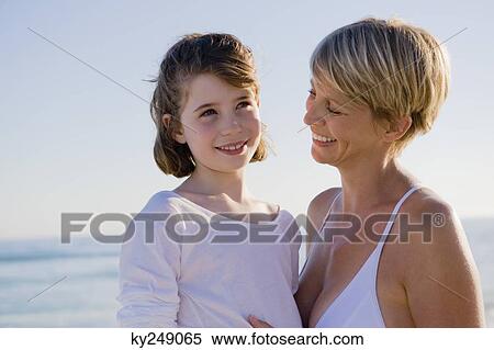 Woman with her daughter enjoying vacations on the beach View Large Photo Image Stock Photography - Woman with her daughter enjoying vacations on the beach. Fotosearch
