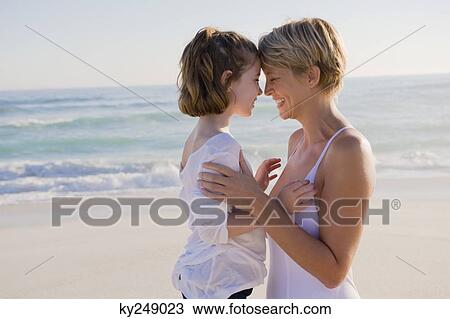 Woman with her daughter rubbing noses on the beach View Large Photo Image Stock Image - Woman with her daughter rubbing noses on the beach. Fotosearch