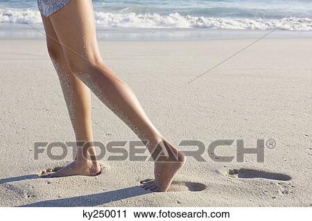 Low section view of a woman walking on the beach View Large Photo Image Stock Image - Low section view of a woman walking on the beach. Fotosearch