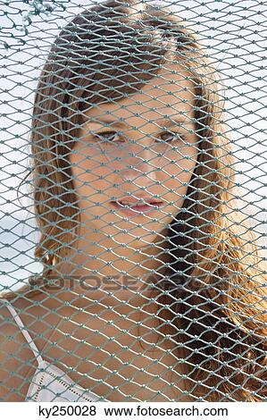 Portrait of a woman behind a net View Large Photo Image Stock Photo - Portrait of a woman behind a net. Fotosearch