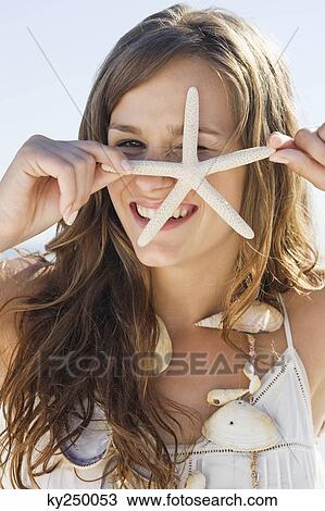 Portrait of a woman holding a starfish and smiling View Large Photo Image Stock Image - Portrait of a woman holding a starfish and smiling. Fotosearch
