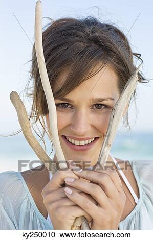 Portrait of a woman holding sticks and smiling View Large Photo Image Stock Image - Portrait of a woman holding sticks and smiling. Fotosearch