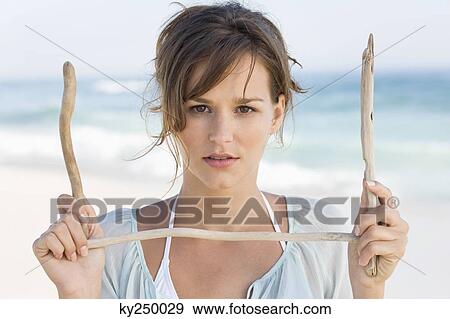 Stock Photo - Portrait of a woman holding sticks. Fotosearch