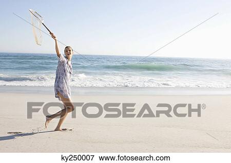 Woman carrying a fishing net on the beach View Large Photo Image Stock Photo - Woman carrying a fishing net on the beach. Fotosearch