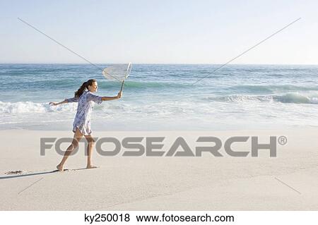 Woman carrying a fishing net on the beach View Large Photo Image Stock Photo - Woman carrying a fishing net on the beach. Fotosearch