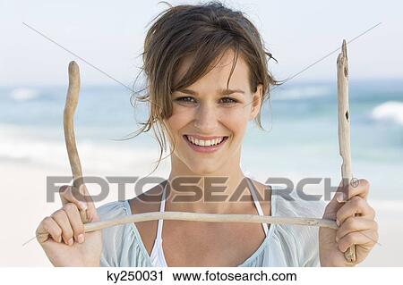 Woman holding sticks and smiling View Large Photo Image Stock Image - Woman holding sticks and smiling. Fotosearch