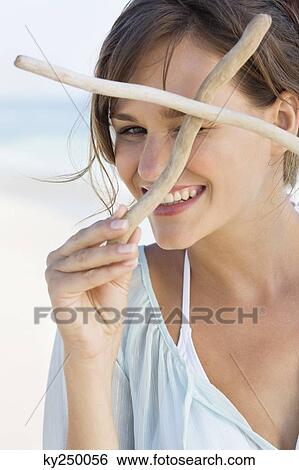 Woman holding sticks and smiling View Large Photo Image Stock Photograph - Woman holding sticks and smiling. Fotosearch