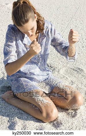 Woman playing with sand on the beach View Large Photo Image Stock Image - Woman playing with sand on the beach. Fotosearch