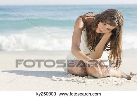 Woman playing with seashells on the beach View Large Photo Image Stock Image - Woman playing with seashells on the beach. Fotosearch