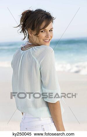 Woman standing on the beach and smiling View Large Photo Image Stock Photography - Woman standing on the beach and smiling. Fotosearch