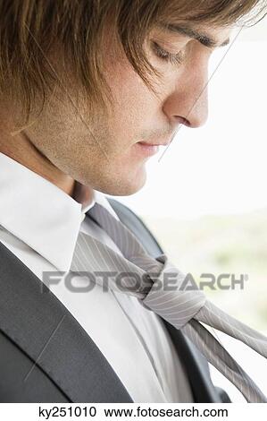 Close-up of a groom adjusting his tie View Large Photo Image Stock Image - Close-up of a groom adjusting his tie. Fotosearch