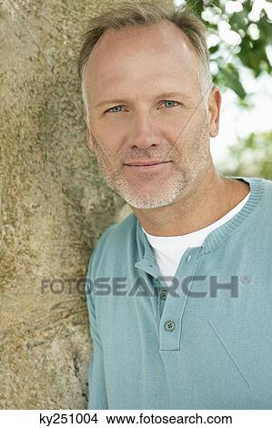 Man leaning against a tree trunk View Large Photo Image Picture - Man leaning against a tree trunk. Fotosearch