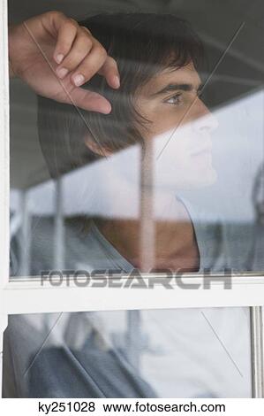 Man looking through glass window View Large Photo Image Stock Photo - Man looking through glass window. Fotosearch