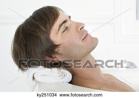 Man lying in a bathtub View Large Photo Image Picture - Man lying in a bathtub. Fotosearch