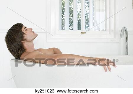 Man lying in a bathtub View Large Photo Image Stock Image - Man lying in a bathtub. Fotosearch