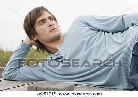 Man lying on a boardwalk View Large Photo Image Stock Photo - Man lying on a boardwalk. Fotosearch