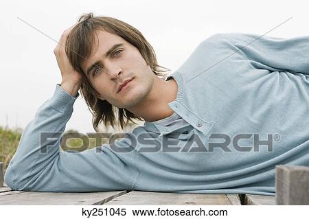 Man lying on a boardwalk View Large Photo Image Stock Photography - Man lying on a boardwalk. Fotosearch